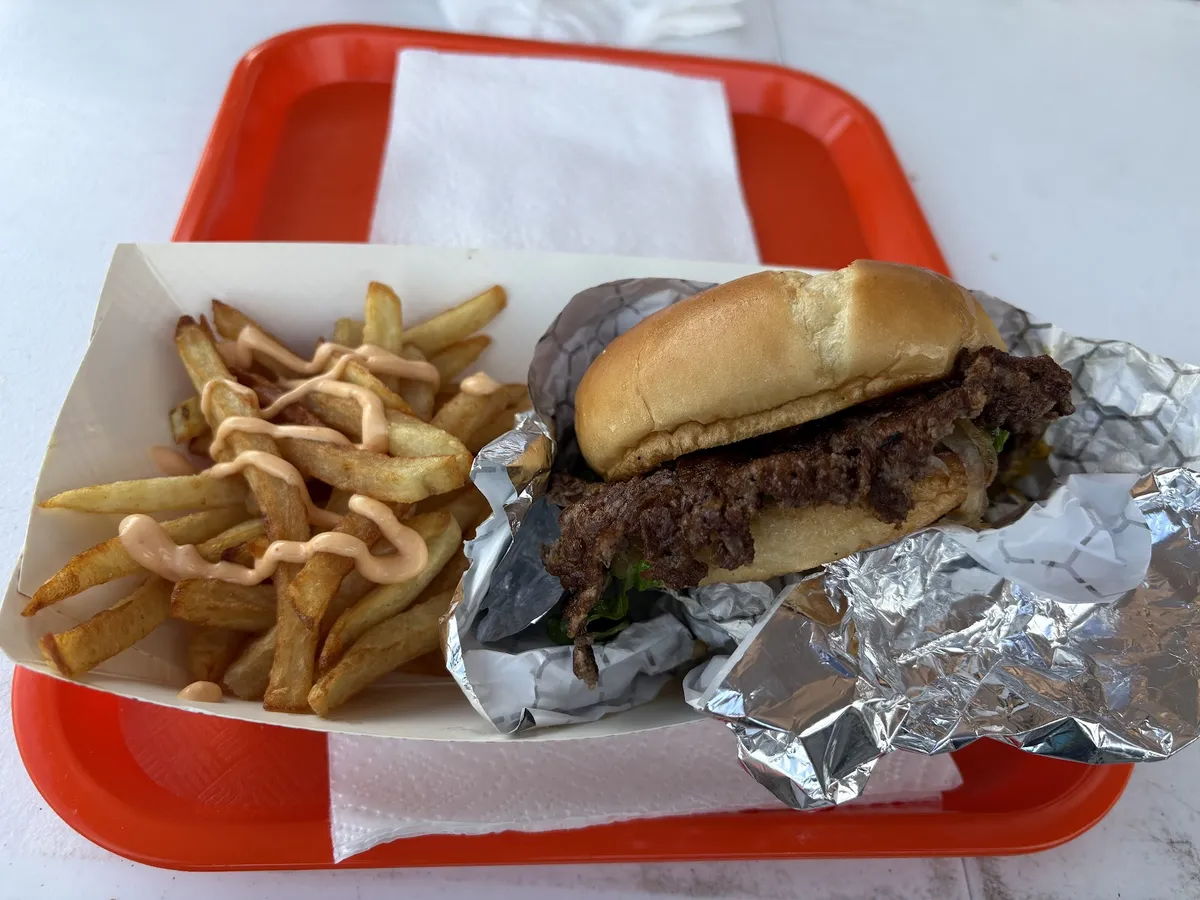 Burger and fries with sauce on a red tray